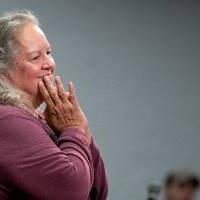 Robin Wall Kimmerer with her hands joined in front of her mouth as a gesture of gratitude